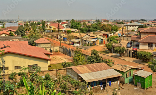Modern residential buildings in Africa. Suburb lifestyle in developing countries. Beautiful urban landscape. Top view. Wonderful houses with red tile roofs, yards, fences, roads, cars