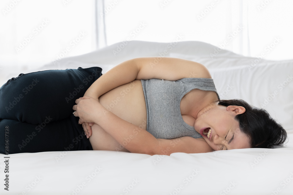 thai pluming woman sleeps pain due to stomach pain giving birth while she is 9 month pregnant on the white bed thai pluming woman sleeps pain due to stomach pain giving birth while she is 9 month pregnant on the white bed