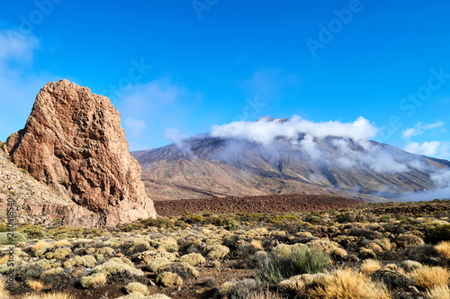 rocks and stones and mountains in the tenerife desert in yellow and orange colors and blue sky