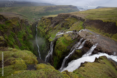 View from the top of Glymur waterfall. Green hills, high waterfall. Iceland