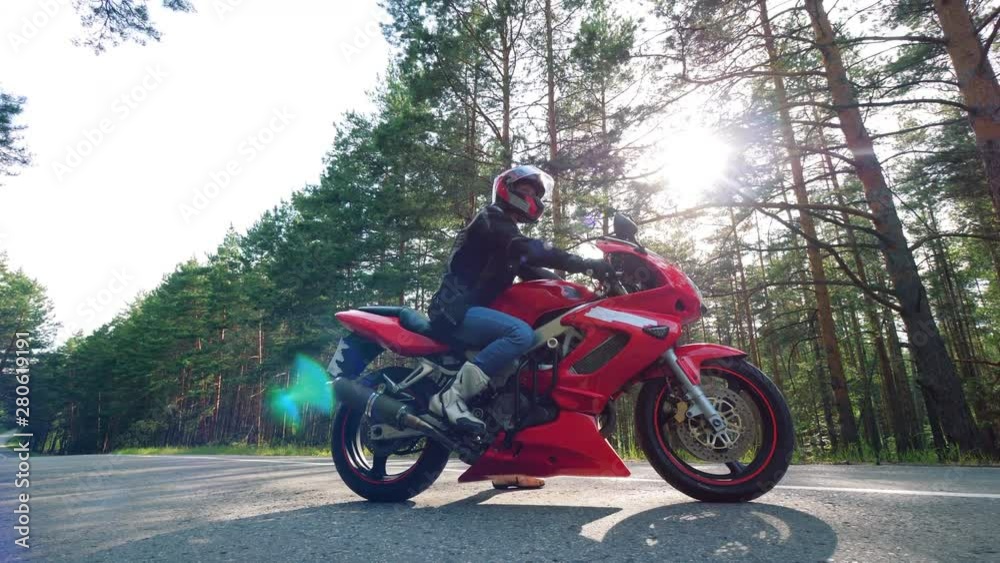 Driver is sitting on the red motorcycle Driver is sitting on the red motorcycle