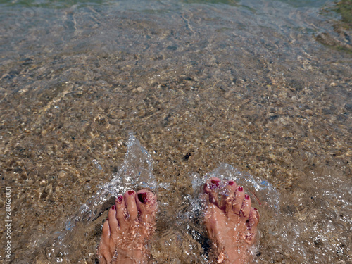 piedi femminili che si intravedono nella trasparenza dell'acqua marina photo