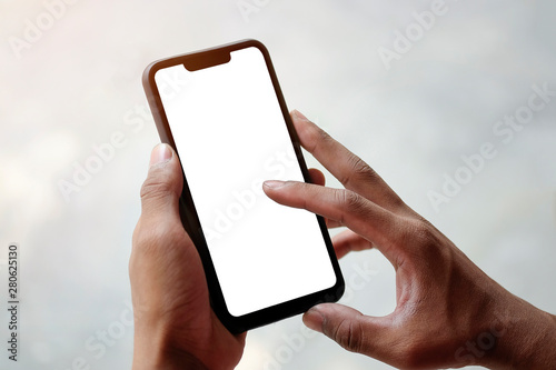 Mock up smartphone of hand holding black mobile phone with blank white screen