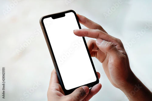 Mock up smartphone of hand holding black mobile phone with blank white screen