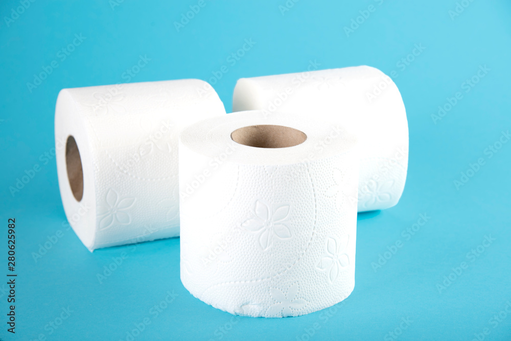 Obraz premium Three rolls of white toilet paper on a colored background