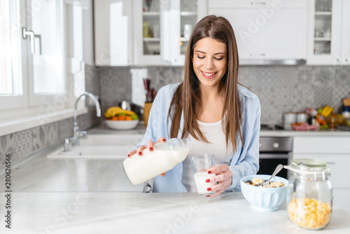 Woman pouring milk onto a bowl of cereal