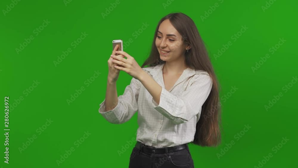 Young positive girl making Photos on a Green Screen, Chroma Key. Traveling. Traveller concept Young positive girl making Photos on a Green Screen, Chroma Key. Traveling. Traveller concept