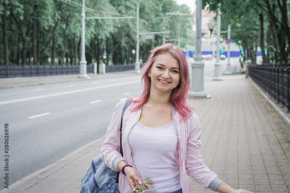 Hipster girl with red hair smiling poses for a photographer