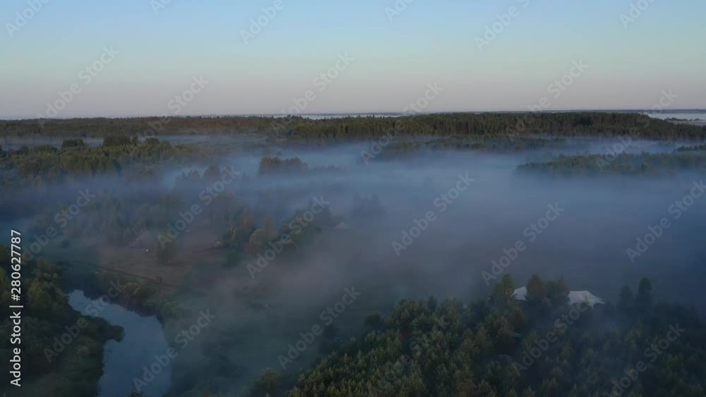 Flying over the forest, river and golden layers of morning fog Flying over the forest, river and golden layers of morning fog