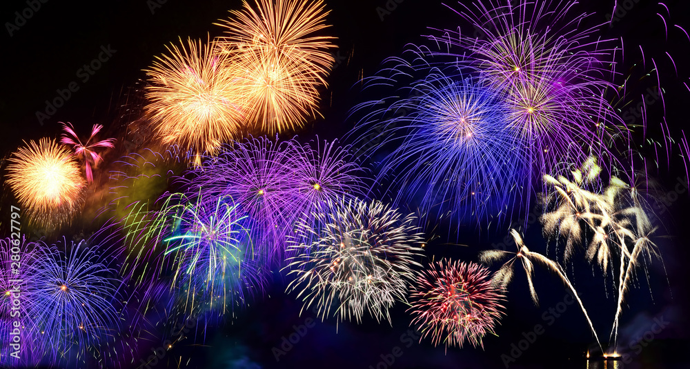Colorful fireworks. Fireworks are a class of explosive pyrotechnic devices used for entertainment purposes. Visible noise due to low light, soft focus, shallow DOF, slight motion blur