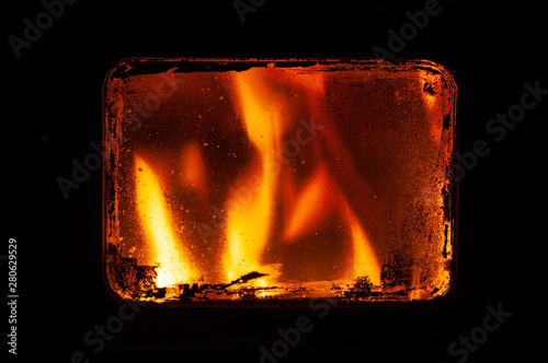 View through the glass on the fire in the furnace