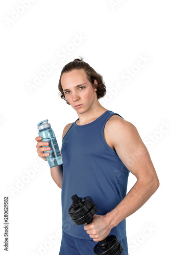 Handsome young man in sport shirt lifting dumbbell and bottle of water. White background isolated