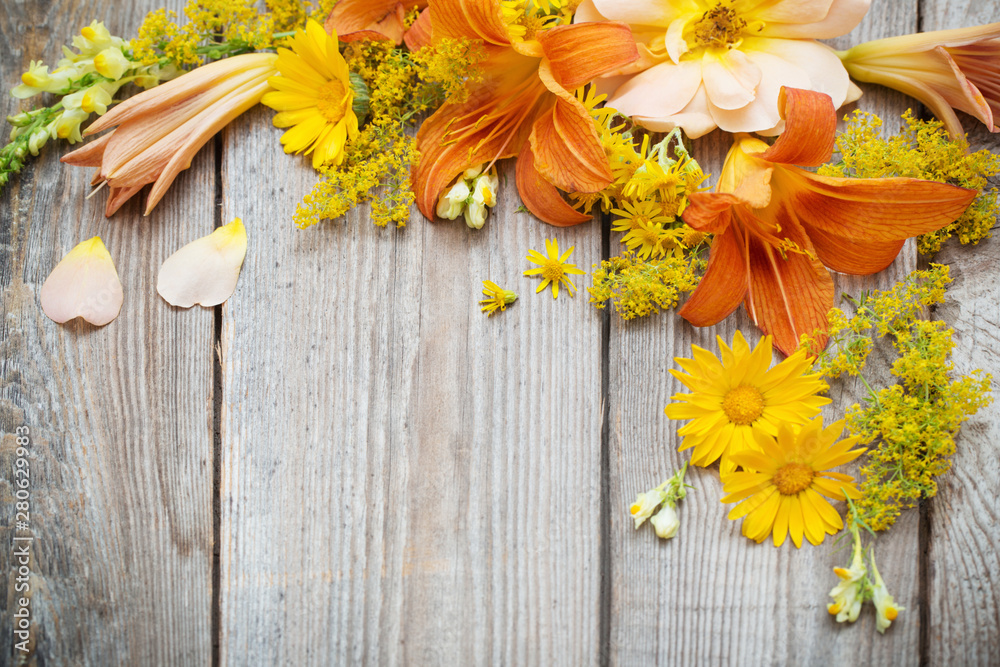 yellow and orange flowers on old wooden background