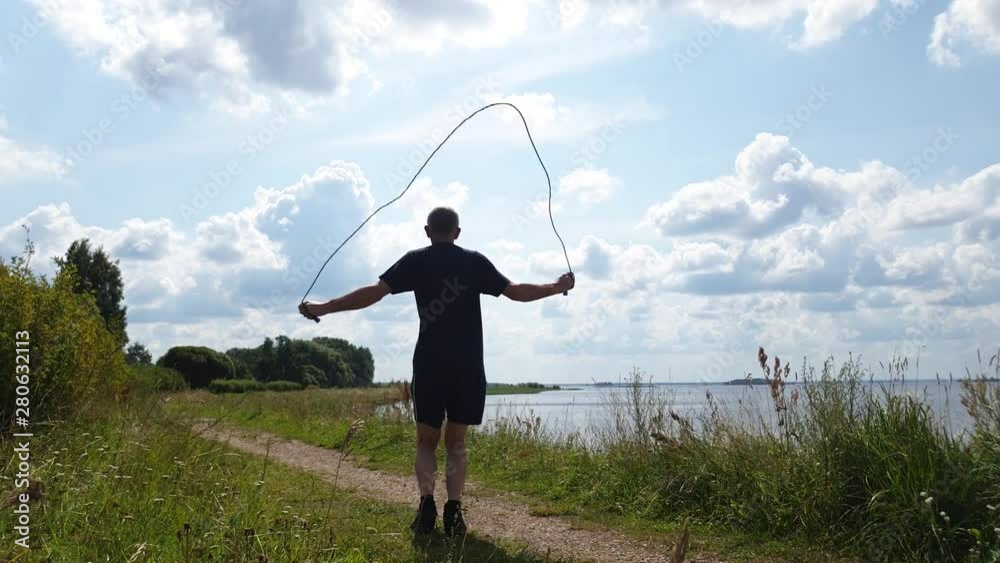 Mature man jumping rope. Man jumping rope in nature. Mature man jumping rope. Man jumping rope in nature.