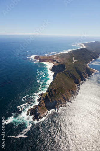 Aerial view of Cape point with lighthouse and Cape of Good Hope from a helicopter. Panorama of South Africa from birds eye view on a sunny day. Edge of the earth from helicopter view.