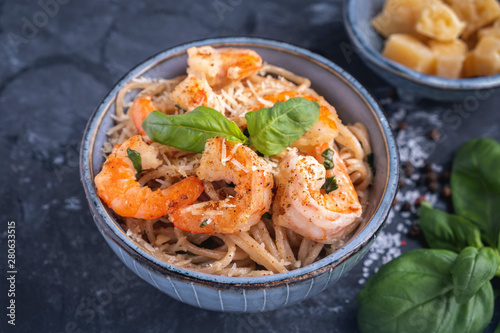 Pasta with shrimps in a plate, close-up. Pasta cooking concept, ingredients and spices on a table with a dish.