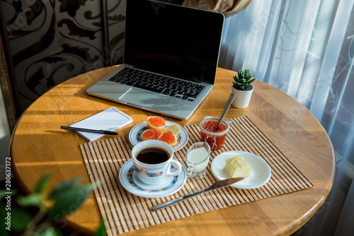 business breakfast   coffee and caviar sandwiches. Cup of coffee with a laptop