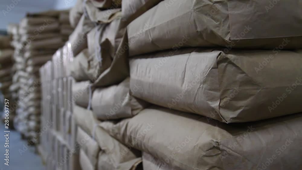 Warehouse space. Logistics center with bags in the enterprise. Products in the warehouse are packed in large stacks in bags, close-up. Bags with products stacked on a stock, ready to be sent for sale. Warehouse space. Logistics center with bags in the enterprise. Products in the warehouse are packed in large stacks in bags, close-up. Bags with products stacked on a stock, ready to be sent for sale.
