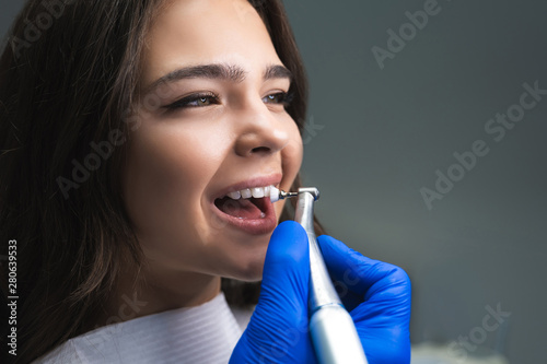 process of using dental brush as a stage of professional dental cleaning procedure in clinic close up