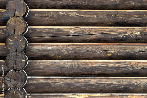 Timber house wall from wood logs. Background with copy space. Close-up front view with corner intersection in left side. Wood annual rings. Place for custom text. Green building concept.