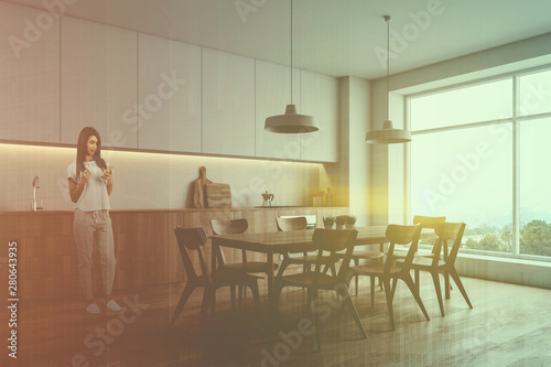 Woman in white kitchen corner with table