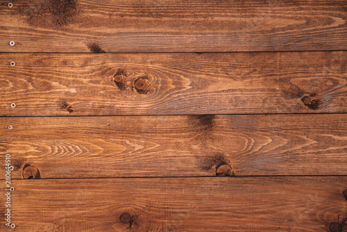 Old brown wood background made of dark natural wood in grunge style. The view from the top. Natural raw planed texture of coniferous pine. The surface of the table to shoot flat lay. Copy space