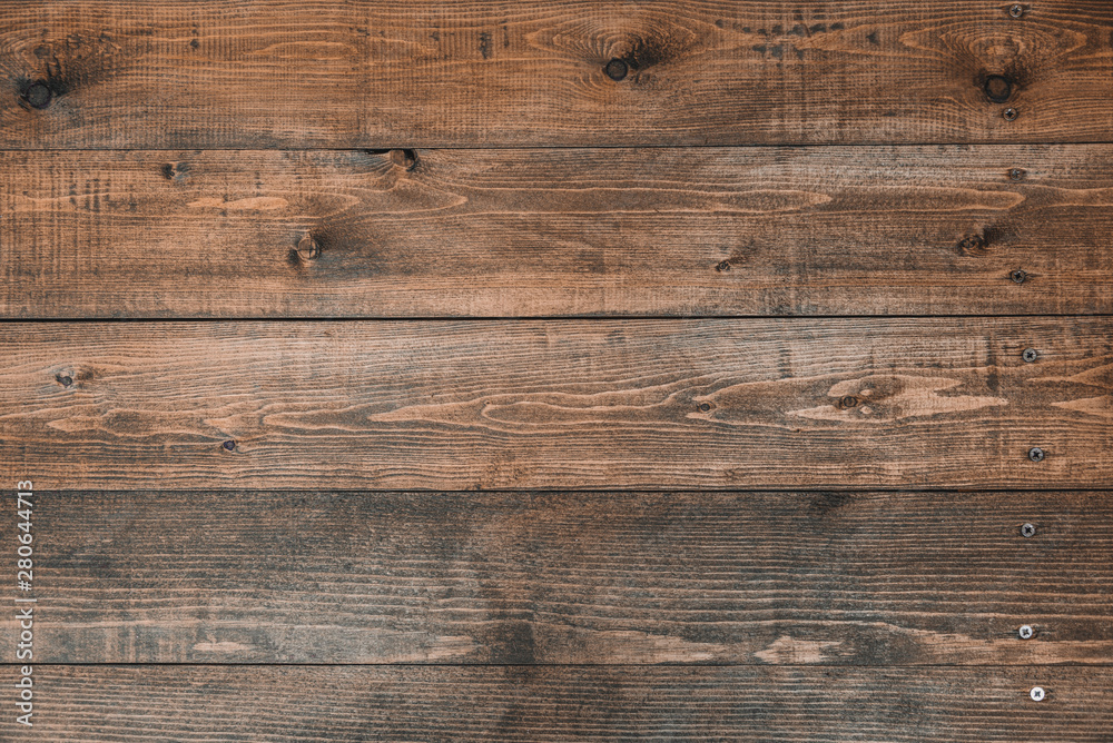 Old brown wood background made of dark natural wood in grunge style. The view from the top. Natural raw planed texture of coniferous pine. The surface of the table to shoot flat lay. Copy space Old brown wood background made of dark natural wood in grunge style. The view from the top. Natural raw planed texture of coniferous pine. The surface of the table to shoot flat lay. Copy space
