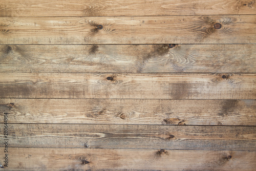Old brown wood background made of dark natural wood in grunge style. The view from the top. Natural raw planed texture of coniferous pine. The surface of the table to shoot flat lay. Copy space