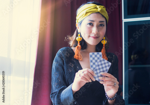 A gypsy or bohemian woman is holding tarot cards photo