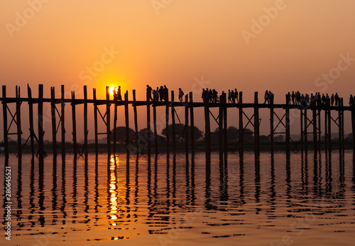 Silhouetted people on U Bein Bridge at sunset  Amarapura  Mandalay region  Myanmar. Burma. The longest and oldest teak wooden bridge in the world