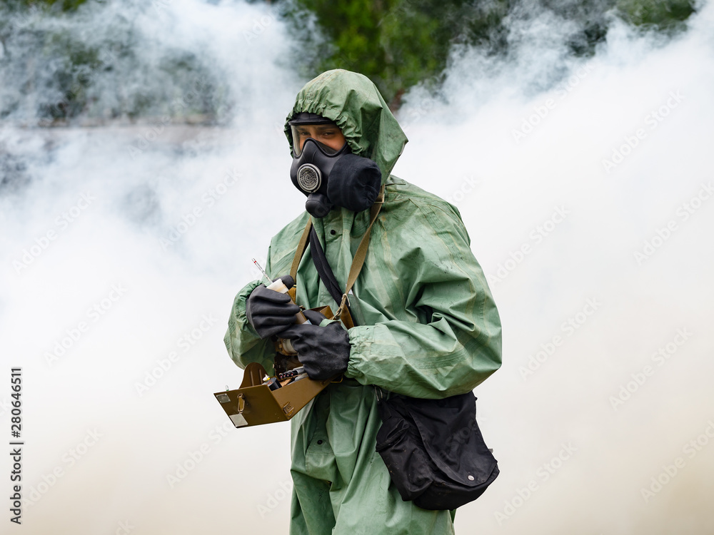 The man in the cost of chemical protection measures the composition of the air