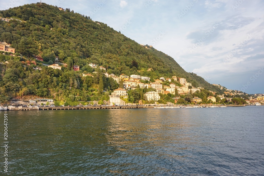 iew from the water of Lake Como in the rays of the setting sun.