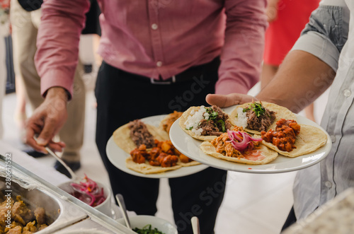 Obraz na płótnie Hombres sirviendo comiendo tacos w salonie
