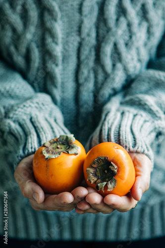 Woman With Ripe Persimmom In Her Hands photo