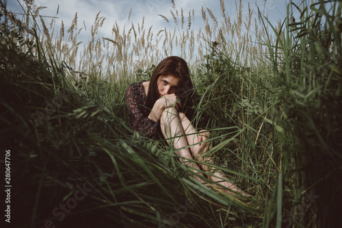 Portrait of young woman sitting in field photo