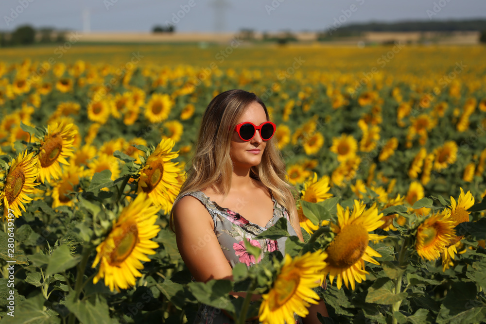 Cute girl in the field full of sunflowers