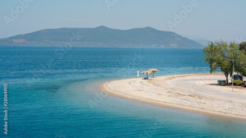 Empty beach in Greece with one sunshade photo