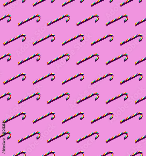 Rainbow-colored candy canes on a magenta background
