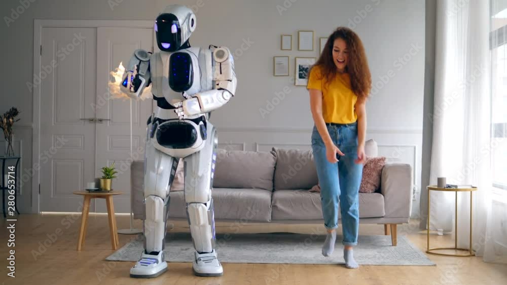 Living room with a lady and a robot dancing joyfully