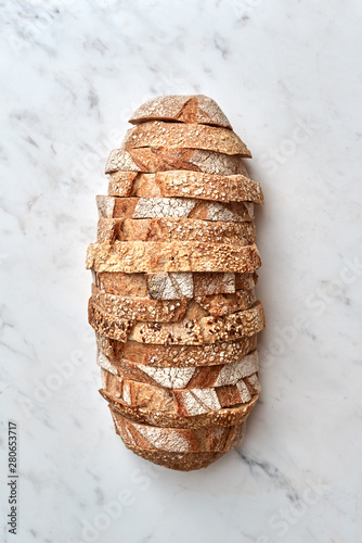 Slices of multigrain organic homemade bread on a gray stone background. Top view.