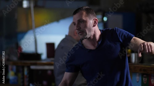 Close-up of drunk man pestering attractive female coming to bar, grasping her hand, pulling using force. Male visitor of cafe defending female neutralizing rowdy using arm lock self defense techniques