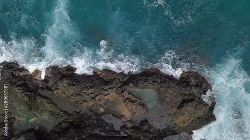 Top view of breaking waves on rock with big footprint photo