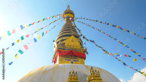 LENS FLARE: Colorful prayer flags flutter in the wind blowing over Monkey Temple