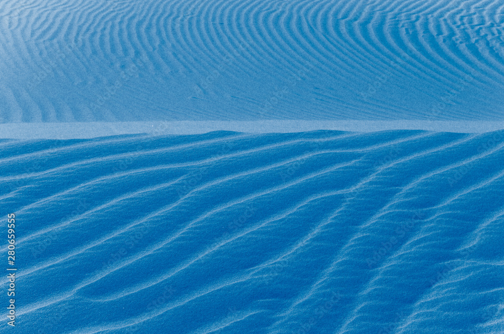 Fototapeta premium Sand texture background. Blue tint.