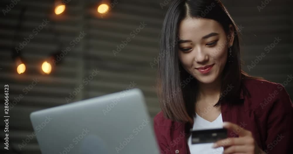 Young asian girl sitting on her bed with laptop, having online shopping, keying in credit card. Panasian student making purchase via internet - closeup 4k Young asian girl sitting on her bed with laptop, having online shopping, keying in credit card. Panasian student making purchase via internet - closeup 4k