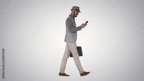 Casual man texting on phone and walking on gradient background. photo