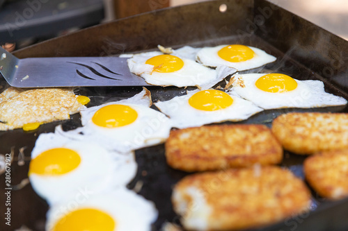 Eggs and hashbrowns on the grill cooking for breakfast photo