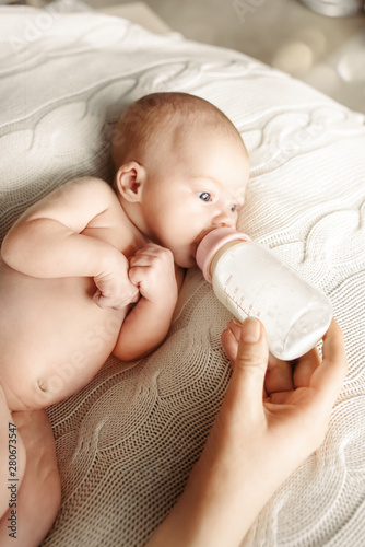 Artificial breastfeeding and bottle feeding the baby. Maternity and healthy lifestyle concept.