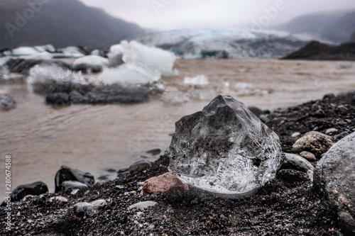 The Solheimajokull Glacier in Iceland showing icebergs and calved ice in the lagoon as ice calves and melts together with the erosion caused by the receding glacier photo