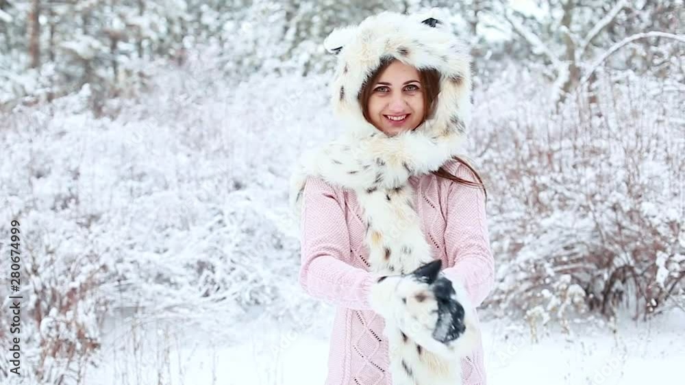 Happy young woman in fur hat playing with snow in frosty winter landscape Happy young woman in fur hat playing with snow in frosty winter landscape